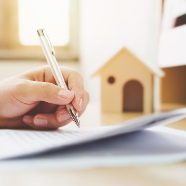 Refinance services represented by a hand signing a document.